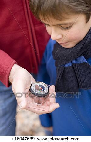 Stock Photo - Father and son reading a compass. Fotosearch