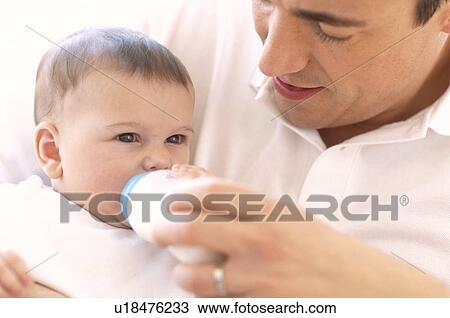 Father bottle-feeding baby girl View Large Photo Image Stock Image - Father bottle-feeding baby girl. Fotosearch