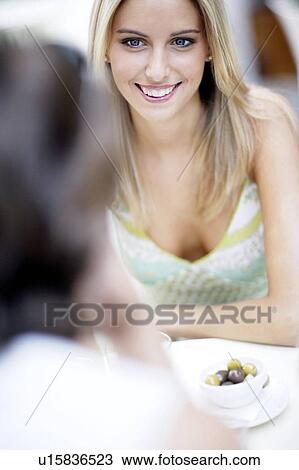 Stock Image - Friends sitting at a table. Fotosearch