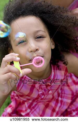 Stock Photography - Girl blowing soap bubbles. Fotosearch