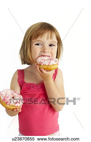 Stock Photography - Girl eating doughnuts. Fotosearch