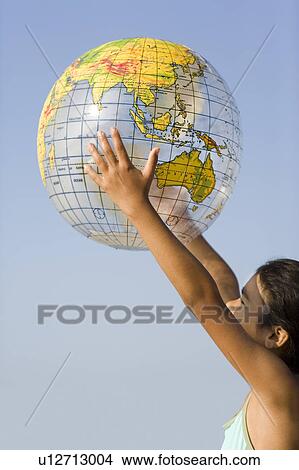 Picture - Girl holding an inflated globe. Fotosearch