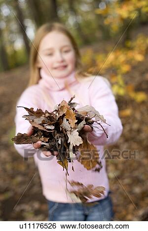 Stock Photograph - Girl holding autumn leaves. Fotosearch