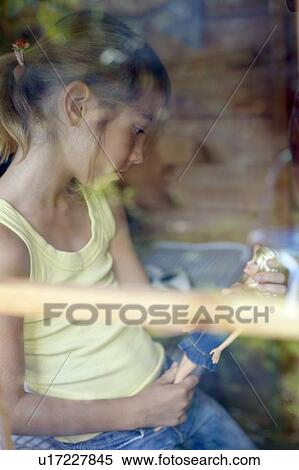 Stock Photography - Girl playing in a Wendy house. Fotosearch