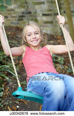 Stock Photo - Girl playing on a swing. Fotosearch