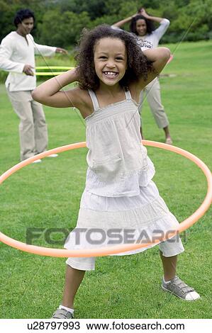 Stock Image - Girl playing with a hula hoop. Fotosearch
