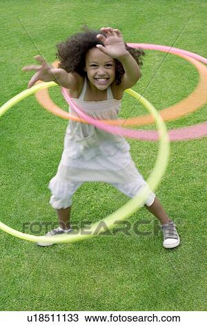 Stock Image - Girl playing with hula hoops. Fotosearch