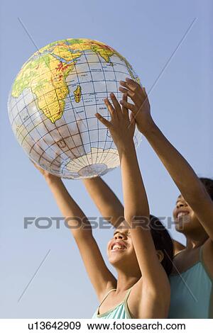 Stock Photo - Girls holding an inflated globe. Fotosearch