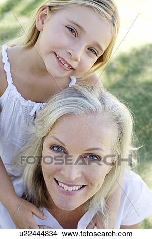 Picture - Granddaughter hugging her grandmother. Fotosearch