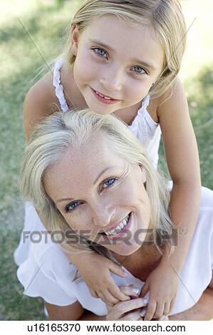 Stock Image - Granddaughter hugging her grandmother. Fotosearch