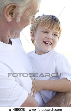 Stock Image - Grandfather holding his grandson. Fotosearch