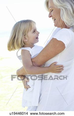 Picture - Grandmother embracing her granddaughter. Fotosearch