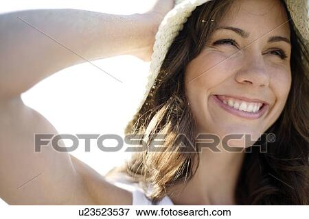 Stock Photo - Happy woman wearing a sunhat. Fotosearch