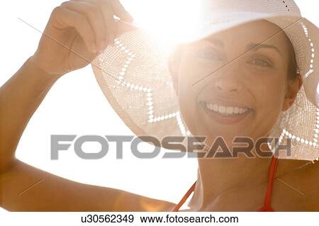 Happy woman wearing a sunhat View Large Photo Image Stock Photo - Happy woman wearing a sunhat. Fotosearch
