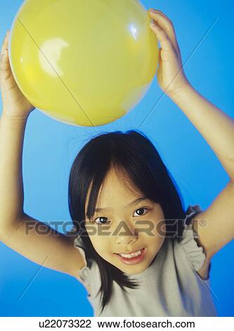 Stock Image - Holding a balloon. Fotosearch