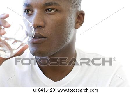 Stock Image - Man drinking a glass of water. Fotosearch