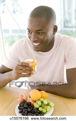 Stock Photograph - Man drinking orange juice. Fotosearch