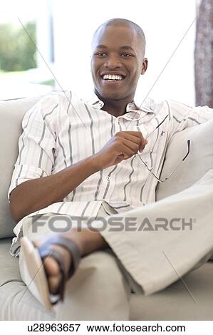 Man holding a pair of glasses View Large Photo Image Stock Photo - Man holding a pair of glasses. Fotosearch