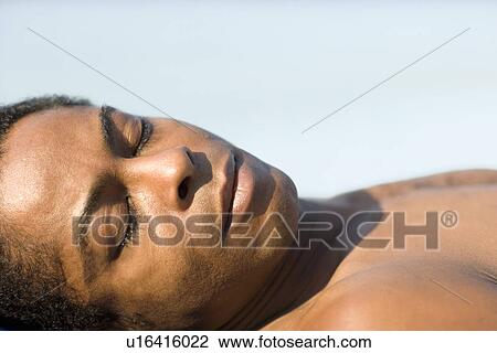 Stock Image - Man sleeping in the sun. Fotosearch