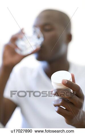 Stock Image - Man taking painkillers. Fotosearch
