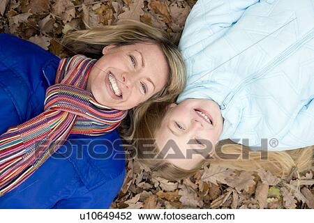 Mother and daughter on autumn leaves View Large Photo Image Stock Image - Mother and daughter on autumn leaves. Fotosearch