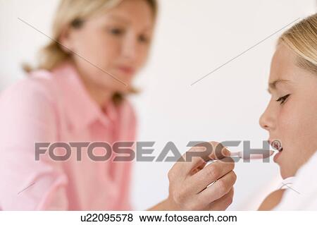 Stock Photo - Mother giving daughter medicine. Fotosearch