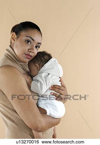 Stock Photograph - Mother holding her baby. Fotosearch