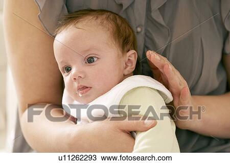 Stock Image - Mother winding her baby. Fotosearch