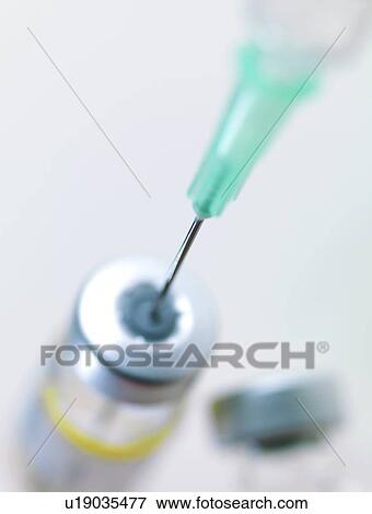 Stock Photo - Needle inserted into a vaccine vial. Fotosearch