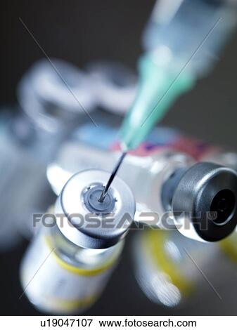 Stock Photo - Needle inserted into a vaccine vial. Fotosearch