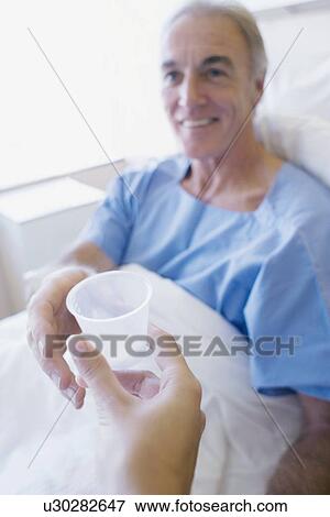 Nurse giving pills to a patient View Large Photo Image Stock Photo - Nurse giving pills to a patient. Fotosearch
