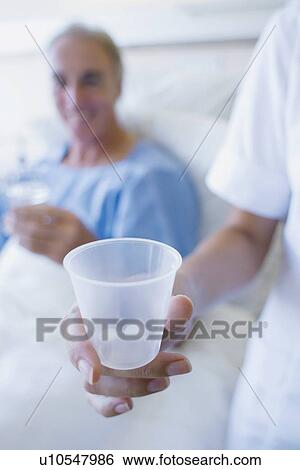 Nurse holding a cup of pills View Large Photo Image Stock Photograph - Nurse holding a cup of pills. Fotosearch