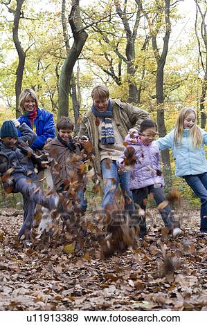 Parents and children playing in a wood View Large Photo Image Stock Photo - Parents and children playing in a wood. Fotosearch