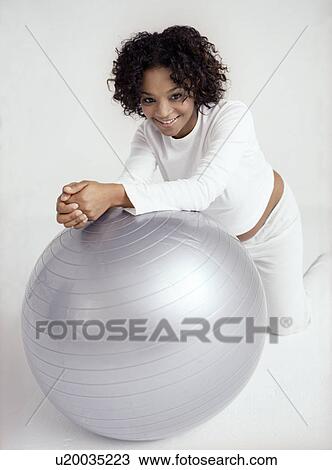 Stock Image - Pregnant woman with birthing ball. Fotosearch