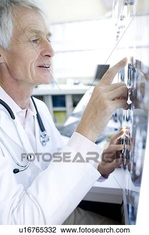 Stock Image - Radiologist studying CT scans. Fotosearch