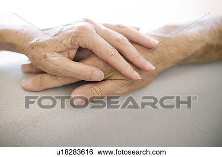 Stock Photograph - Senior couple holding hands. Fotosearch