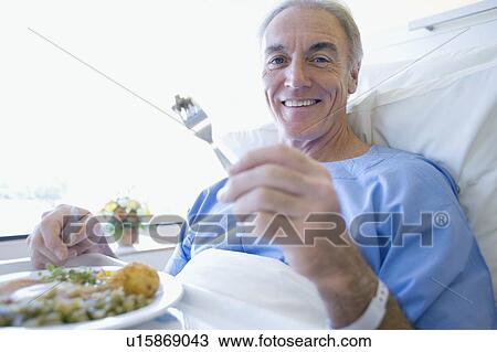 Stock Image - Senior patient eating a hospital meal. Fotosearch