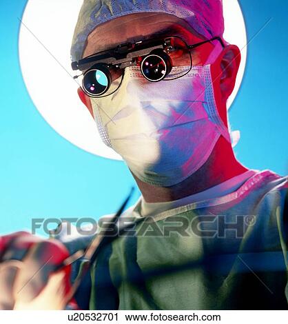 Stock Image - Surgeon carries out microsurgery. Fotosearch