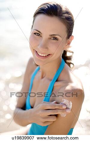 Woman applying sunscreen View Large Photo Image Stock Photo - Woman applying sunscreen. Fotosearch