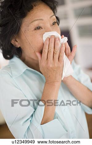 Stock Photo - Woman blowing her nose. Fotosearch