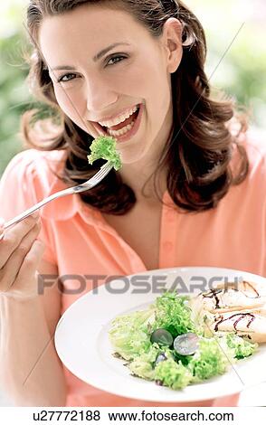 Woman eating a salad View Large Photo Image Stock Photo - Woman eating a salad. Fotosearch
