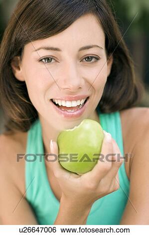 Stock Photograph - Woman eating an apple. Fotosearch