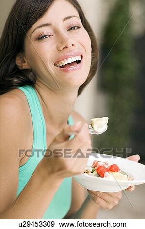 Stock Photo - Woman eating fruit salad. Fotosearch