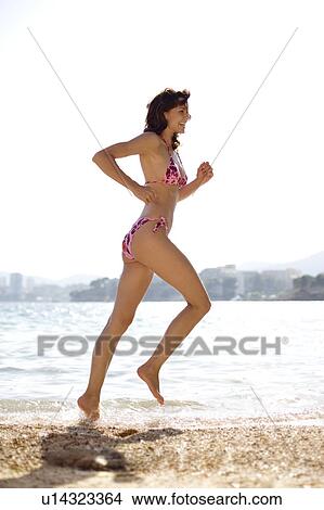 Woman jogging on a beach View Large Photo Image Picture - Woman jogging on a beach. Fotosearch