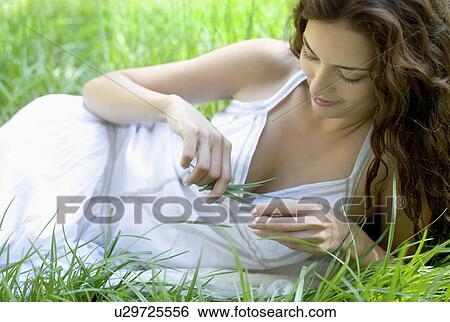 Stock Photograph - Woman playing with the grass. Fotosearch