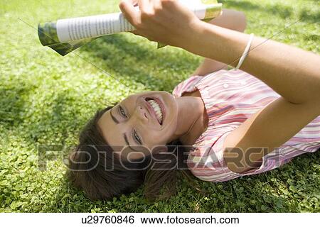 Stock Photograph - Woman reading in the shade. Fotosearch