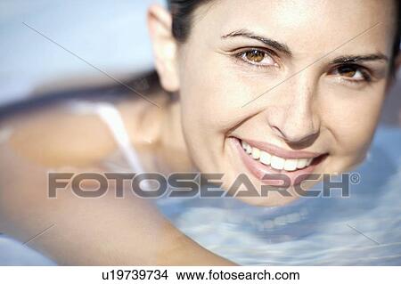 Picture - Woman relaxing in a swimming pool. Fotosearch