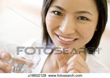 Stock Photo - Woman taking a pill. Fotosearch
