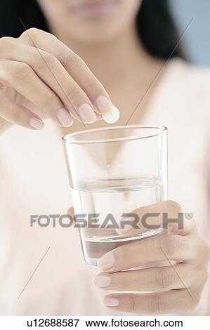 Woman taking a soluble pill View Large Photo Image Stock Photo - Woman taking a soluble pill. Fotosearch