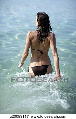 Woman walking into the sea View Large Photo Image Stock Photo - Woman walking into the sea. Fotosearch